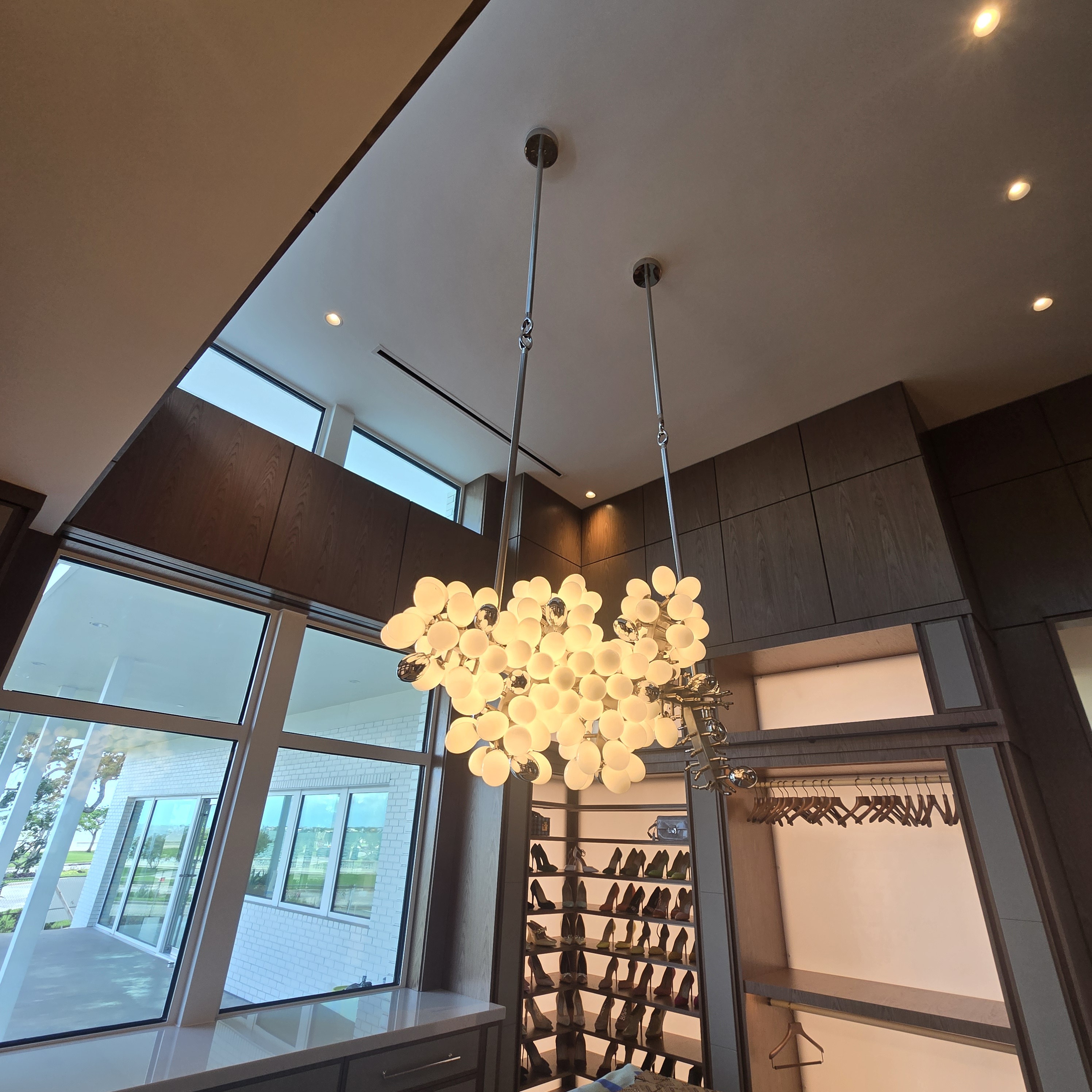 Custom cluster chandelier in a two-story walk-in closet