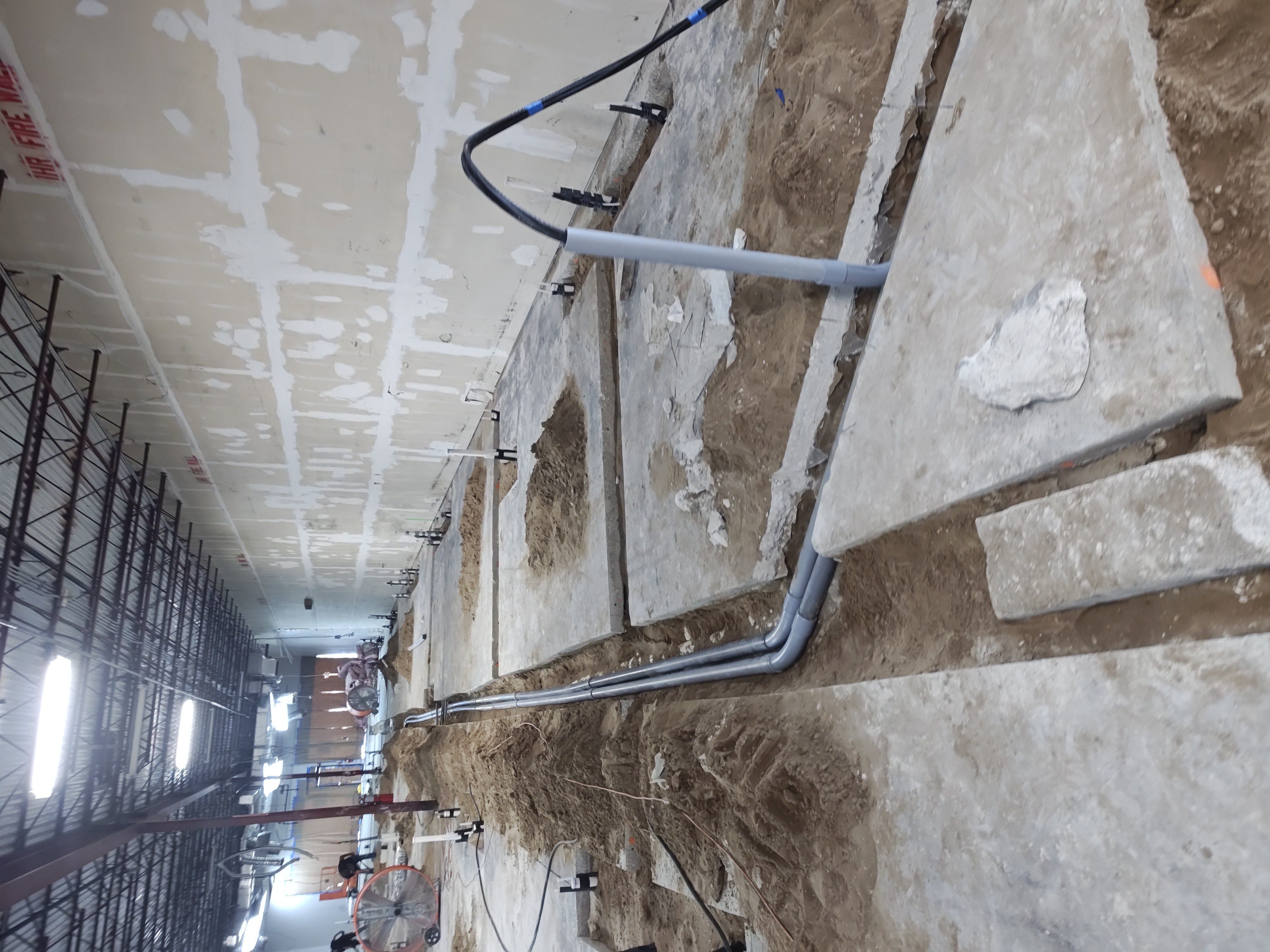 Underground PVC conduit runs roughed into the slab at a commercial construction site